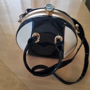 Black and tan vinyl purse with large rhinestone closure nob at the top of purse